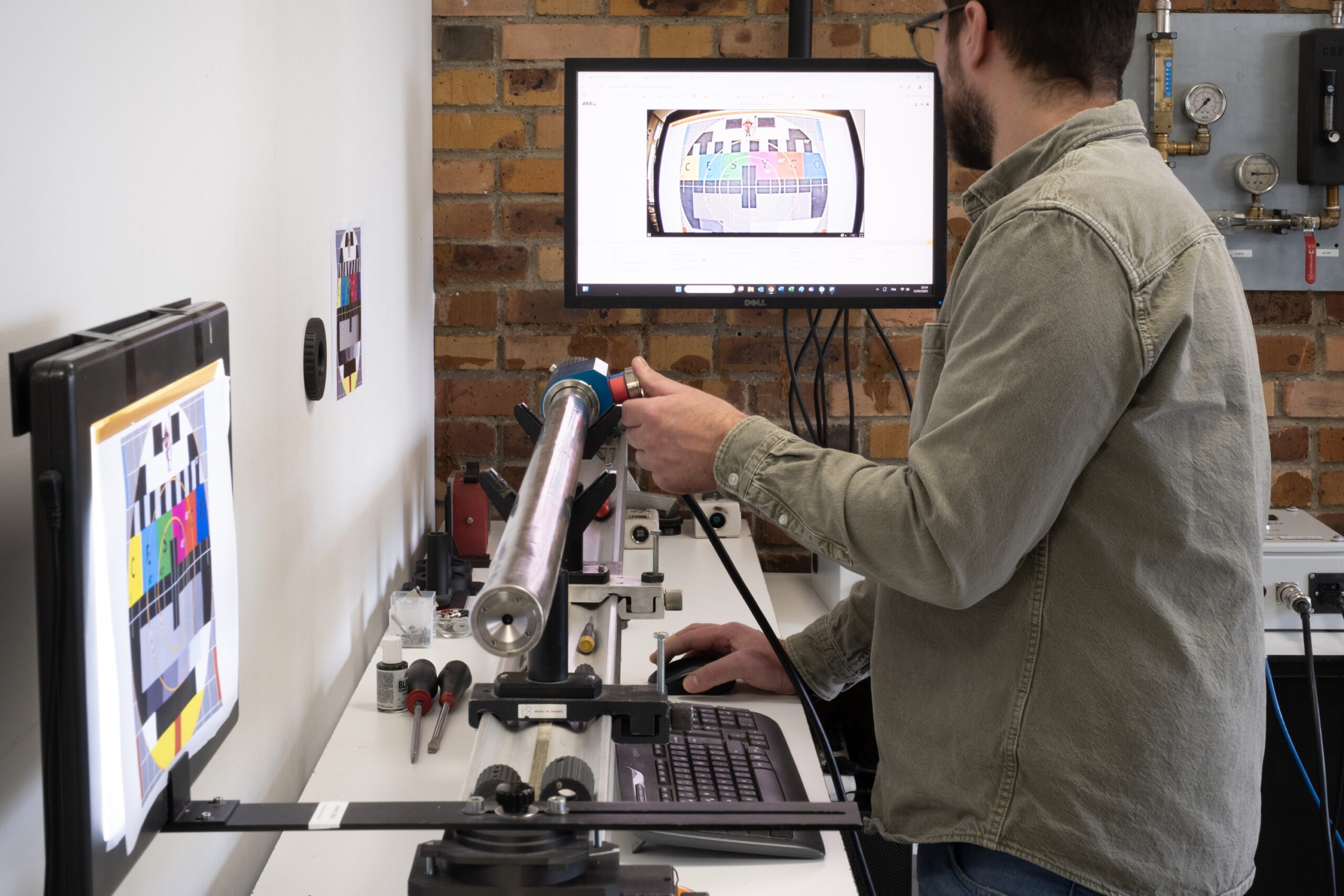 Control Technician performing a performance test on an endoscope in a control room, with image quality displayed on the screen.